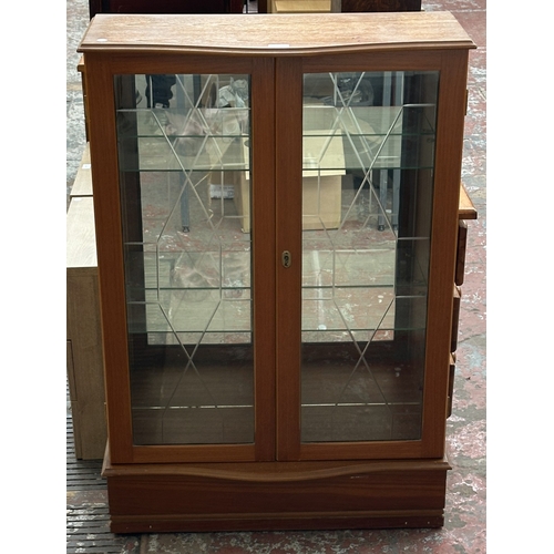 131 - A teak glazed two door display cabinet with two glass shelves - approx. 108cm high x 74cm wide x 33c... 