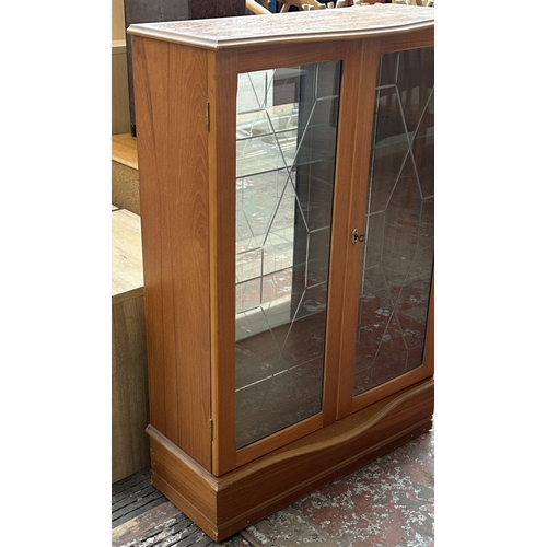 131 - A teak glazed two door display cabinet with two glass shelves - approx. 108cm high x 74cm wide x 33c... 