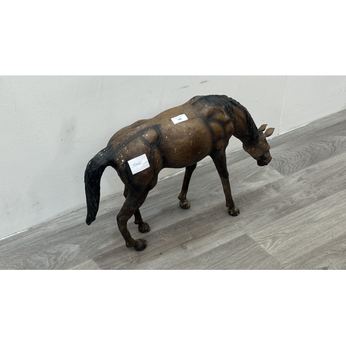 142 - A Liberty & Co. style leather model of a grazing horse - approx. 39cm high x 59cm long