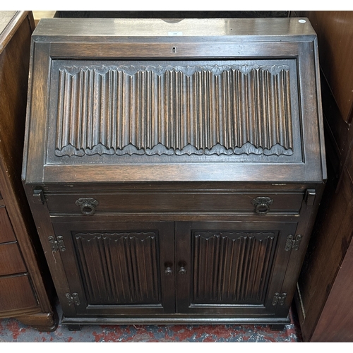 144 - A Wood Bros ‘Old Charm’ carved oak linenfold bureau - approx. 97cm high x 75cm wide x 42cm deep