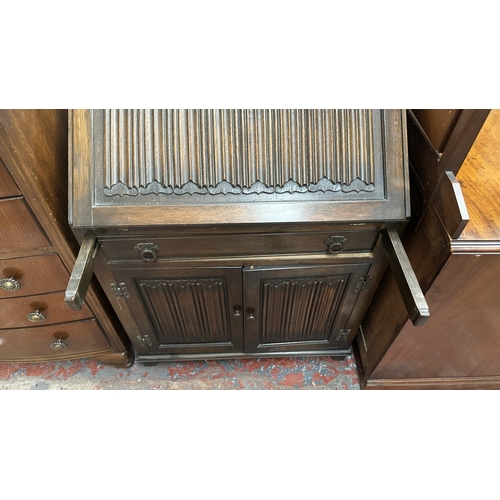 144 - A Wood Bros ‘Old Charm’ carved oak linenfold bureau - approx. 97cm high x 75cm wide x 42cm deep