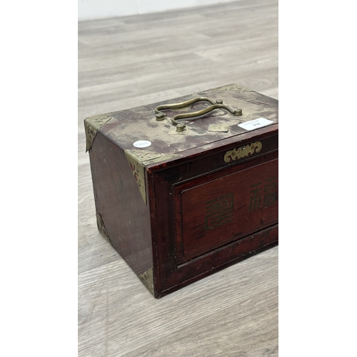 152 - An early 20th century Chinese stained wooden and brass cased mahjong set featuring one hundred and f... 