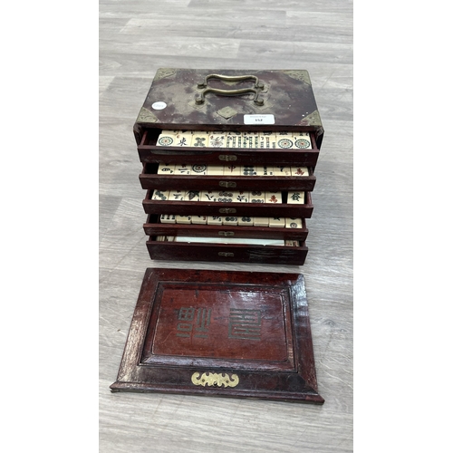 152 - An early 20th century Chinese stained wooden and brass cased mahjong set featuring one hundred and f... 