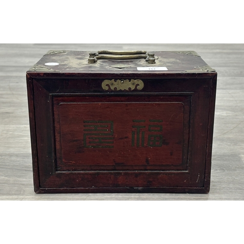152 - An early 20th century Chinese stained wooden and brass cased mahjong set featuring one hundred and f... 