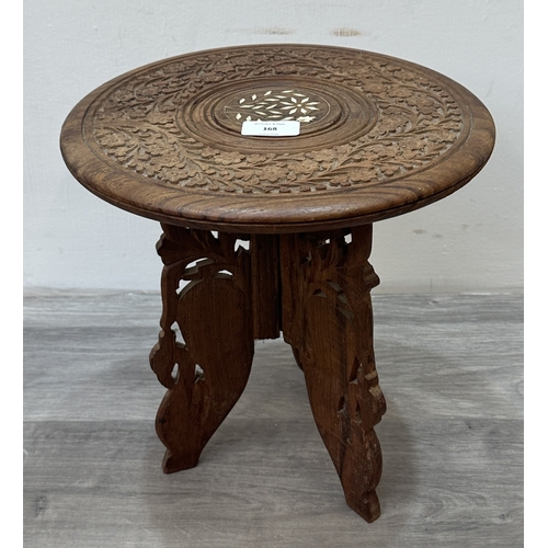 168 - An Indian inlaid and carved teak circular folding side table with floral design - approx. 31cm high ... 