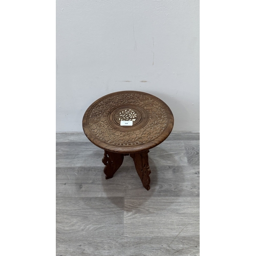 168 - An Indian inlaid and carved teak circular folding side table with floral design - approx. 31cm high ... 