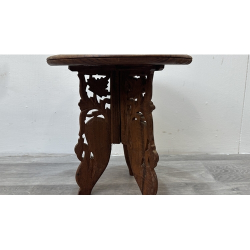 168 - An Indian inlaid and carved teak circular folding side table with floral design - approx. 31cm high ... 