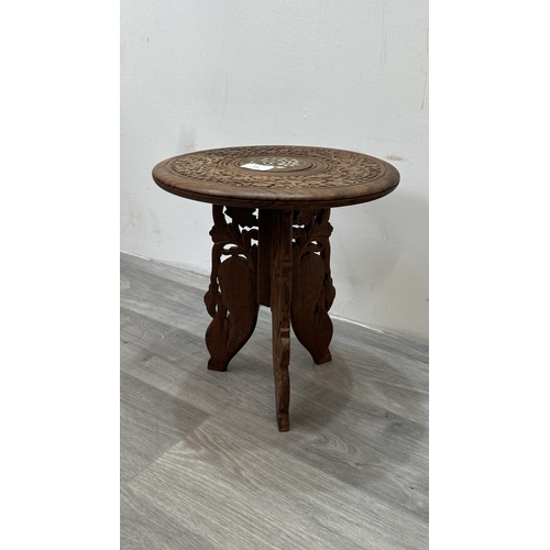168 - An Indian inlaid and carved teak circular folding side table with floral design - approx. 31cm high ... 