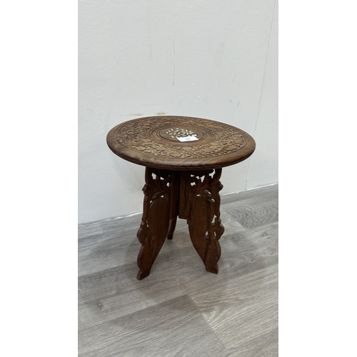 168 - An Indian inlaid and carved teak circular folding side table with floral design - approx. 31cm high ... 
