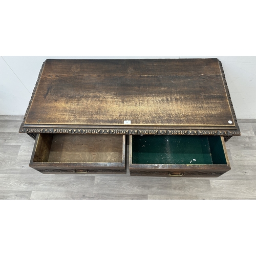 179 - A Victorian Gothic Revival carved oak two drawer hall/writing table - approx. 77cm high x 121cm wide... 