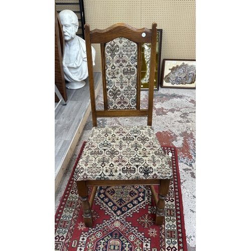 182 - A Wood Bros 'Old Charm' oak draw leaf dining table on carved baluster supports and six tapestry upho... 