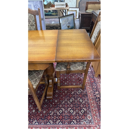 182 - A Wood Bros 'Old Charm' oak draw leaf dining table on carved baluster supports and six tapestry upho... 