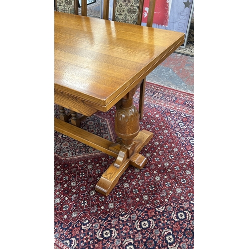 182 - A Wood Bros 'Old Charm' oak draw leaf dining table on carved baluster supports and six tapestry upho... 