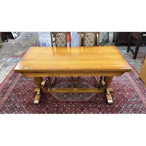 182 - A Wood Bros 'Old Charm' oak draw leaf dining table on carved baluster supports and six tapestry upho... 