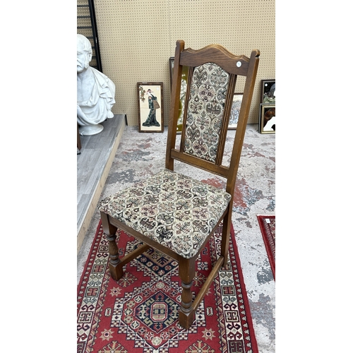 182 - A Wood Bros 'Old Charm' oak draw leaf dining table on carved baluster supports and six tapestry upho... 