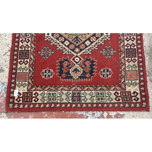 184 - A Persian style machine woven red ground geometric patterned hall runner - approx. 325cm x 80cm