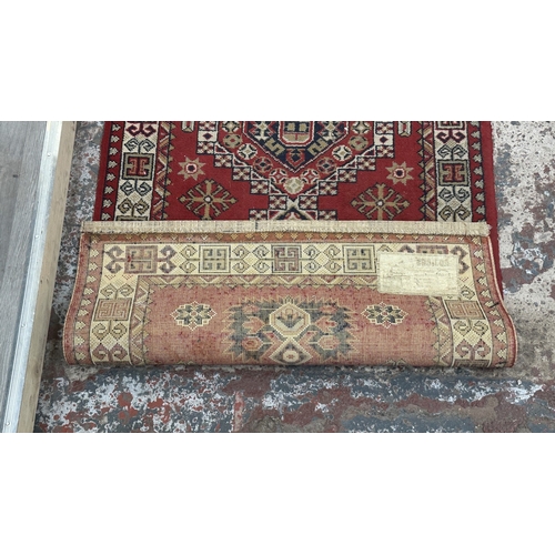 184 - A Persian style machine woven red ground geometric patterned hall runner - approx. 325cm x 80cm