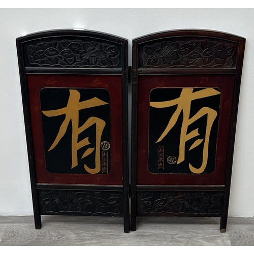 198 - A Chinese lacquered and carved wooden two section folding screen - approx. 91cm high x 86cm wide