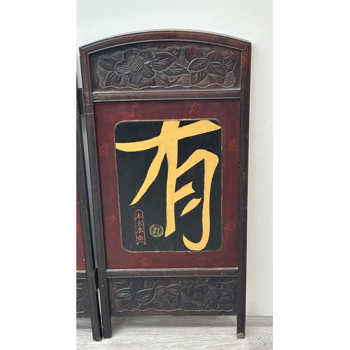 198 - A Chinese lacquered and carved wooden two section folding screen - approx. 91cm high x 86cm wide