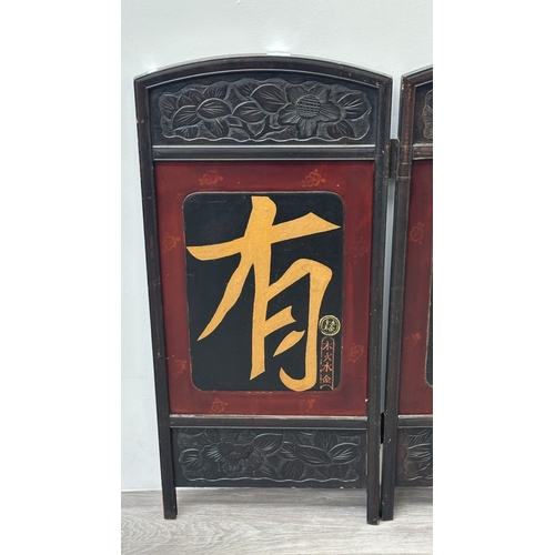 198 - A Chinese lacquered and carved wooden two section folding screen - approx. 91cm high x 86cm wide