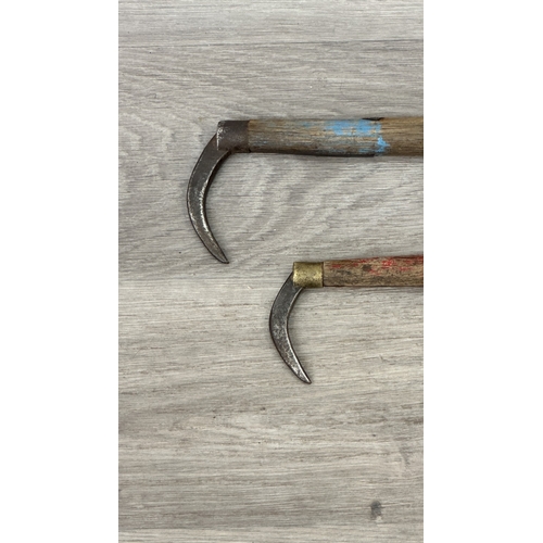 205 - Two early 20th century Japanese wood and iron tuna gaffs, signed to base - largest approx. 39cm long