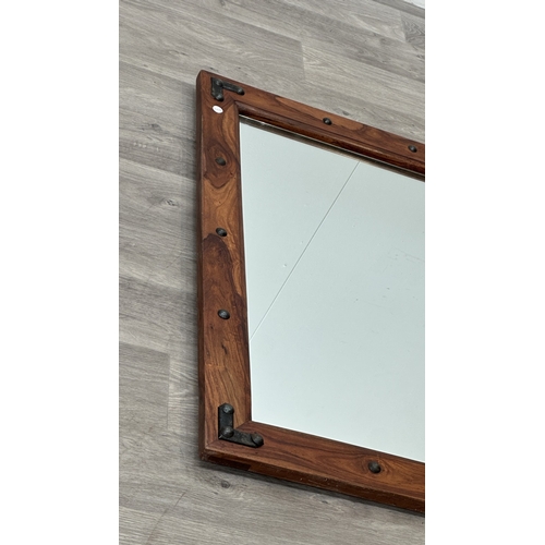 219 - An Indian sheesham wood framed wall mirror with metal decoration - approx. 90cm high x 70cm wide