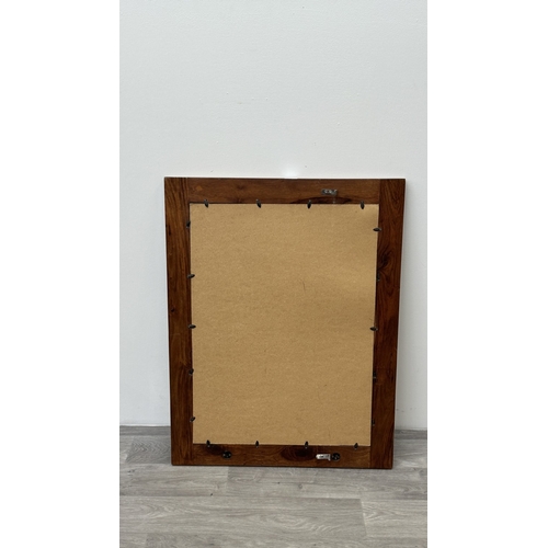 219 - An Indian sheesham wood framed wall mirror with metal decoration - approx. 90cm high x 70cm wide