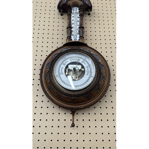 235 - A late 19th/early 20th century carved walnut framed aneroid barometer - approx. 56cm high x 23cm wid... 