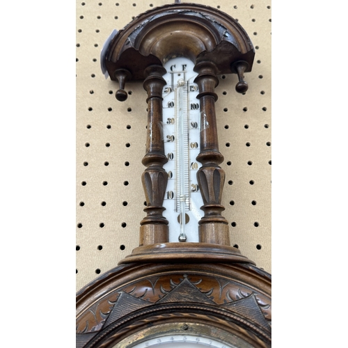 235 - A late 19th/early 20th century carved walnut framed aneroid barometer - approx. 56cm high x 23cm wid... 