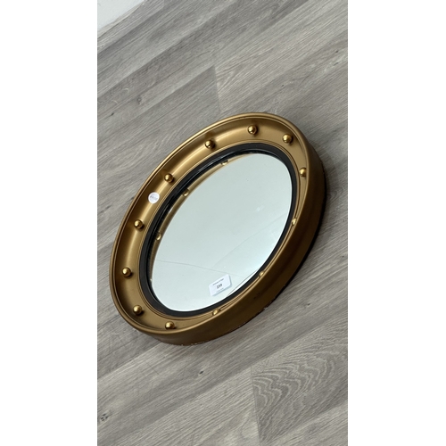 239 - A mid 20th century Regency style gilt framed circular convex wall mirror bearing label to reverse 'A... 