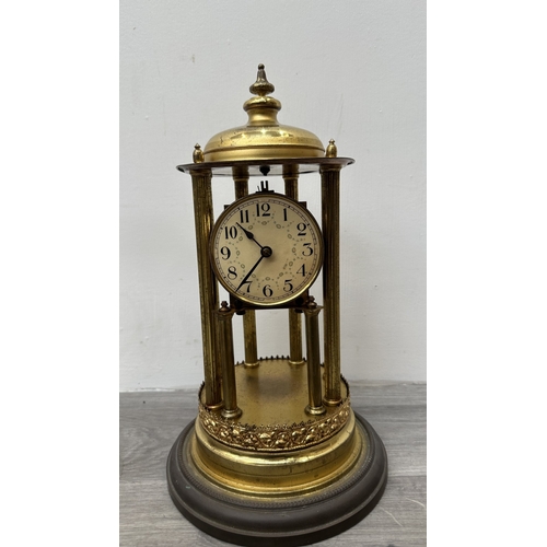 247 - A German brass 400-day torsion clock with glass dome, key, pendulum and B crescent moon logo to reve... 