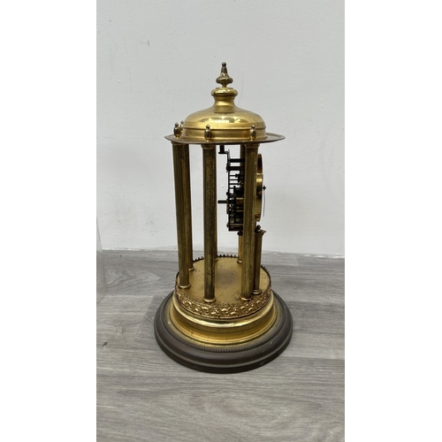 247 - A German brass 400-day torsion clock with glass dome, key, pendulum and B crescent moon logo to reve... 
