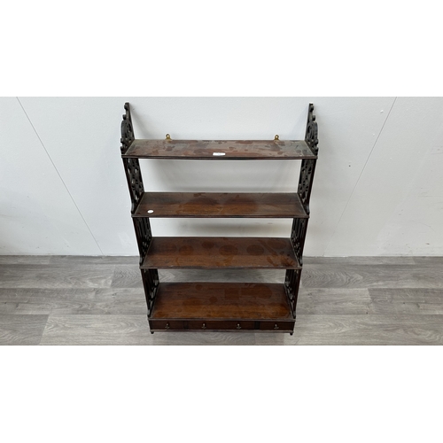 252 - A Georgian style carved mahogany four tier wall hanging shelving unit with fretwork sides - approx. ... 