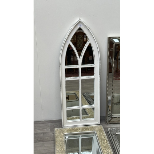 255 - Four modern framed wall mirrors, one white painted arched, one silver painted and bevelled, one Fren... 