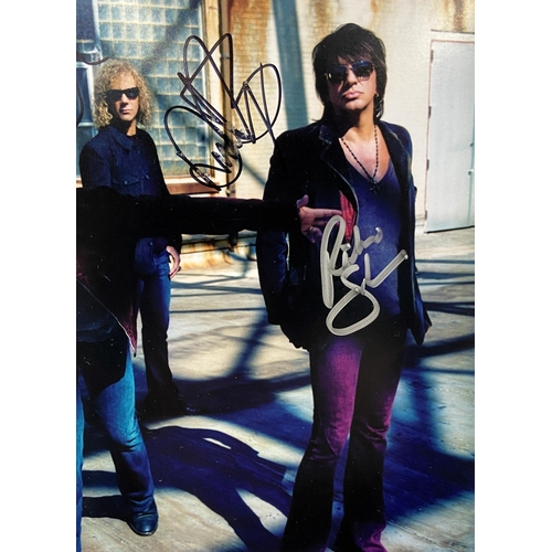 114 - A signed colour photograph of Bon Jovi features hand-signed autographs from band members Jon Bon Jov... 