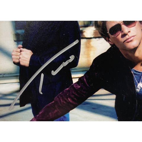 114 - A signed colour photograph of Bon Jovi features hand-signed autographs from band members Jon Bon Jov... 