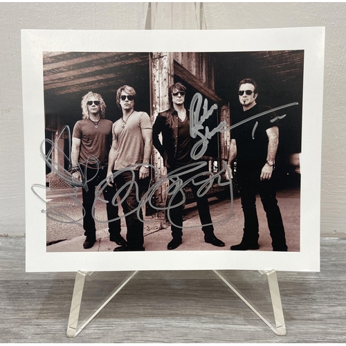 115 - A signed photograph of Bon Jovi features hand-signed autographs from band members Jon Bon Jovi, Rich... 