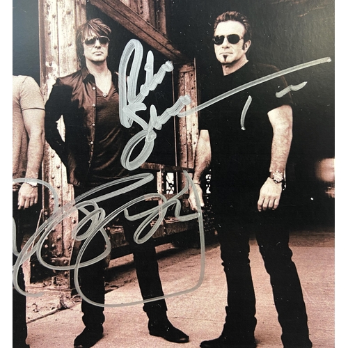 115 - A signed photograph of Bon Jovi features hand-signed autographs from band members Jon Bon Jovi, Rich... 