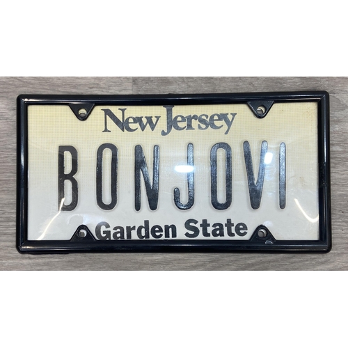 91 - Two Bon Jovi New Jersey-themed novelty license plates, one white with 