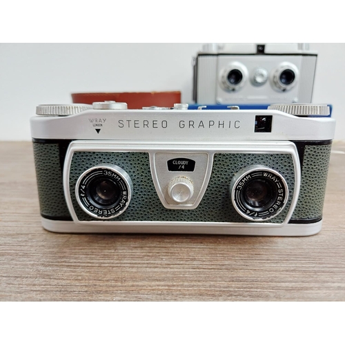 Two 1950s 35mm stereo cameras with instruction manuals, one boxed ...