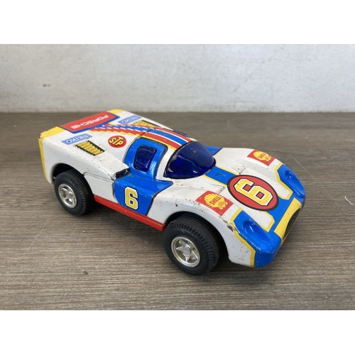 587 - A box containing six toy vehicles to include tinplate Crusader tank - made in Great Britain, Porsche... 