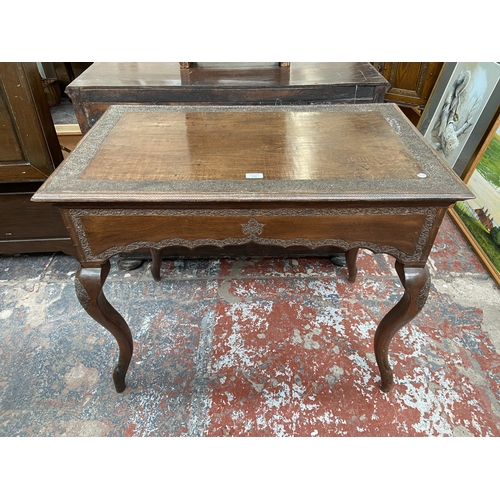 246 - A late 19th/early 20th century carved mahogany writing table with foliate design and cabriole suppor... 