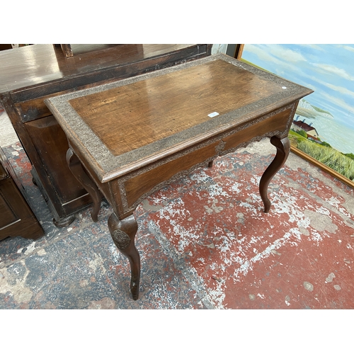 246 - A late 19th/early 20th century carved mahogany writing table with foliate design and cabriole suppor... 