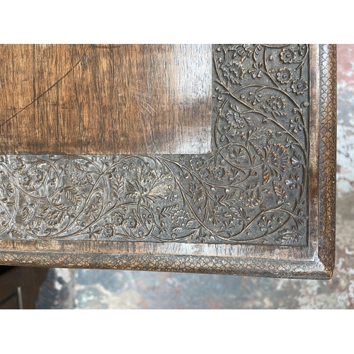 246 - A late 19th/early 20th century carved mahogany writing table with foliate design and cabriole suppor... 
