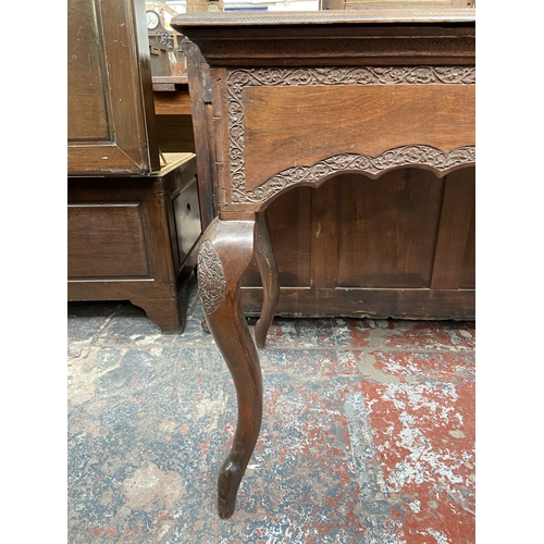 246 - A late 19th/early 20th century carved mahogany writing table with foliate design and cabriole suppor... 