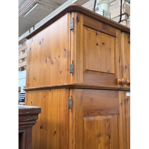 107 - A pine double wardrobe with upper storage compartment - approx. 221cm high x 90cm wide x 60cm deep