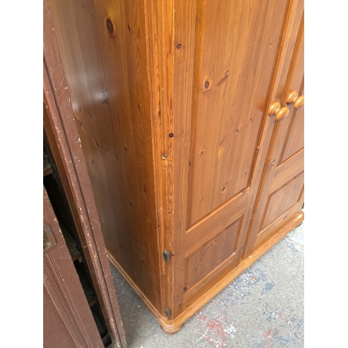 107 - A pine double wardrobe with upper storage compartment - approx. 221cm high x 90cm wide x 60cm deep
