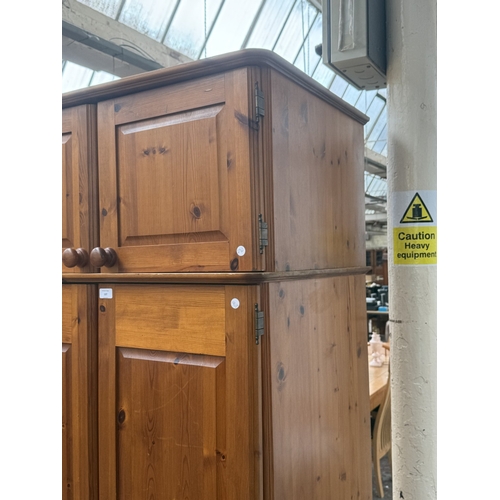 107 - A pine double wardrobe with upper storage compartment - approx. 221cm high x 90cm wide x 60cm deep