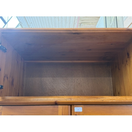 107 - A pine double wardrobe with upper storage compartment - approx. 221cm high x 90cm wide x 60cm deep