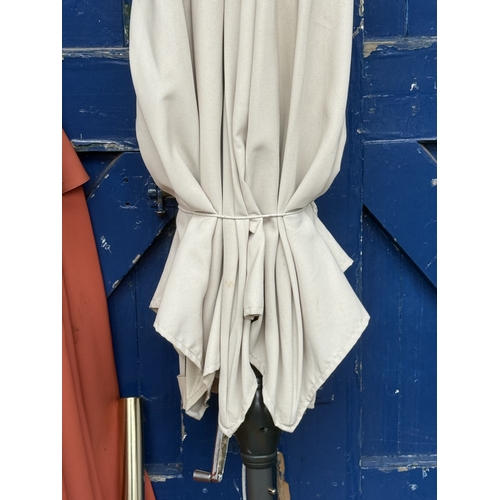 112 - Two garden parasols, one grey metal and beige fabric and one wood and orange fabric - approx. larges... 